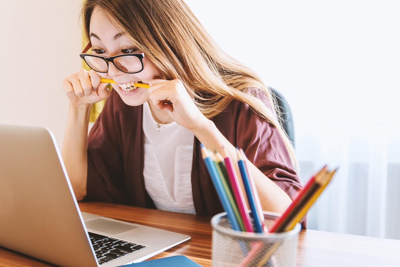 Vrouw berekent haar uurtarief als zelfstandige achter een laptop met notities