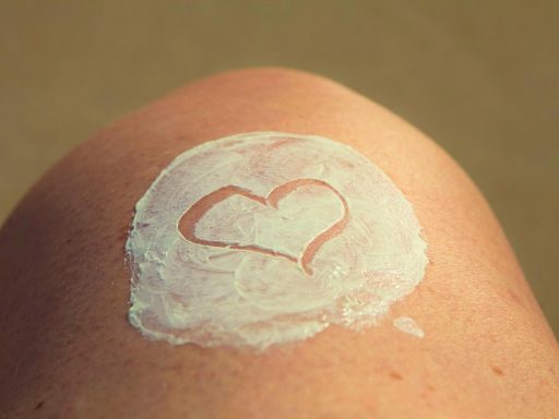 Vrouw die een lichte bodylotie aanbrengt op haar benen op een zomerse dag