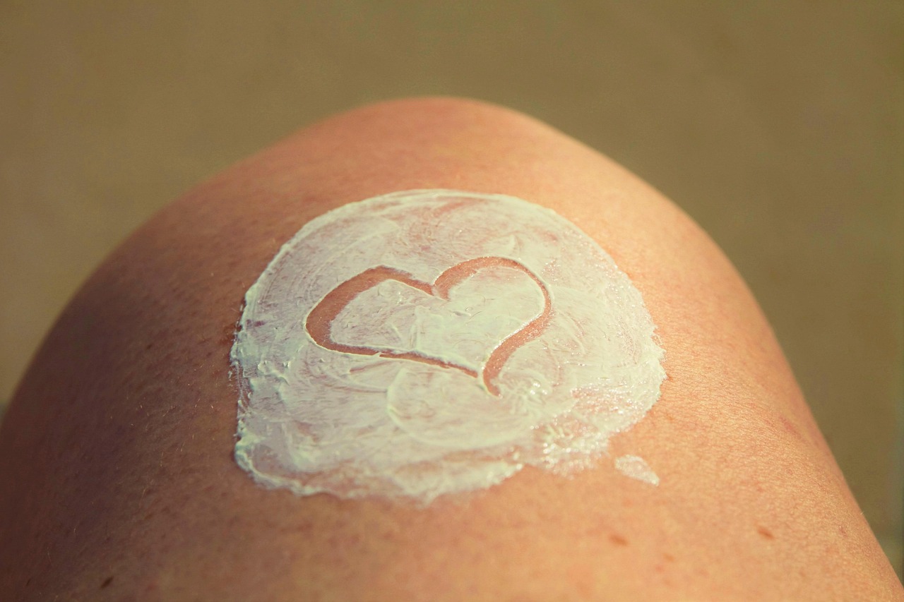Vrouw die een lichte bodylotie aanbrengt op haar benen op een zomerse dag