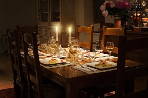 Zelfgemaakte menukaart op een sfeervolle gedekte tafel met kaarsen en serviesgoed
