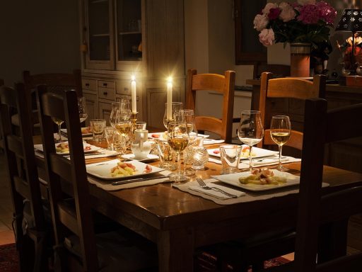 Zelfgemaakte menukaart op een sfeervolle gedekte tafel met kaarsen en serviesgoed