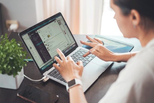 Vrouw werkt geconcentreerd op laptop aan keukentafel thuis