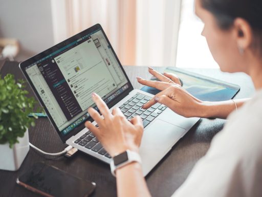 Vrouw werkt geconcentreerd op laptop aan keukentafel thuis