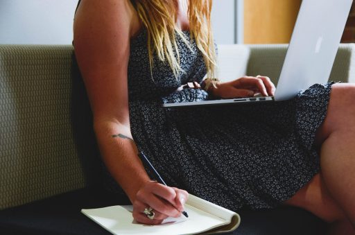 Vrouw werkt thuis achter laptop in een verzorgde maar comfortabele outfit met blazer