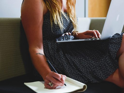 Vrouw werkt thuis achter laptop in een verzorgde maar comfortabele outfit met blazer