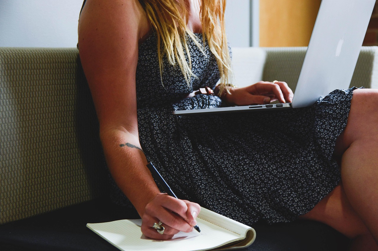 Vrouw werkt thuis achter laptop in een verzorgde maar comfortabele outfit met blazer