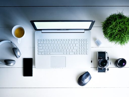 Een opgeruimd en licht thuiskantoor met een plant en een weekplanner op het bureau