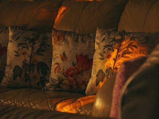 Woonkamer met herfstkleuren: kussens in okergeel en terracotta op een neutrale bank