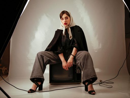 Een vrouwelijke tv-presentatrice staat klaar in een televisiestudio met verlichting op de achtergrond